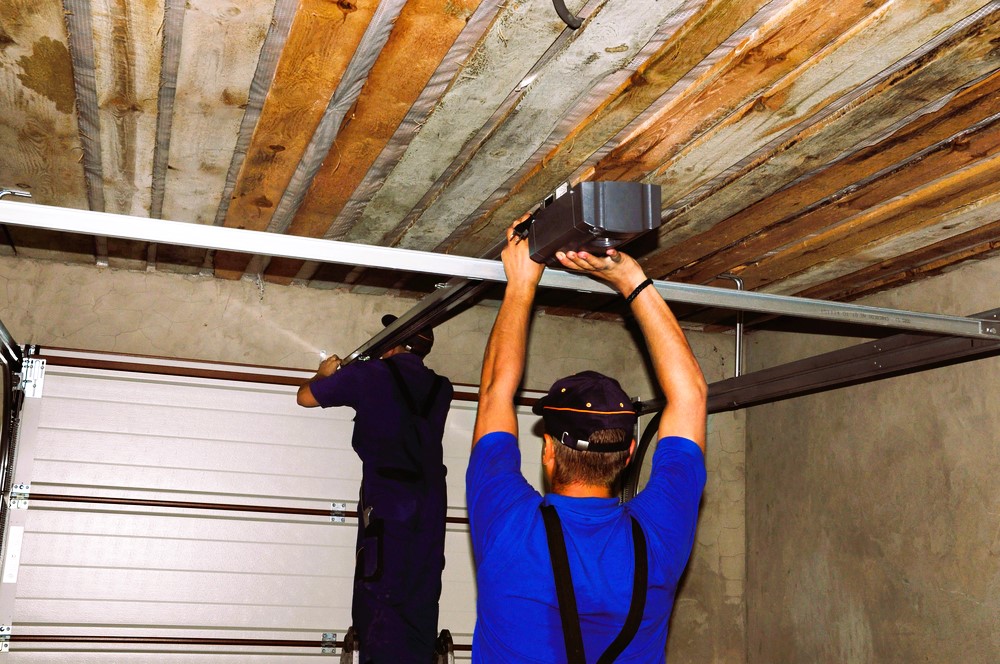 Contractors installing garage door opener